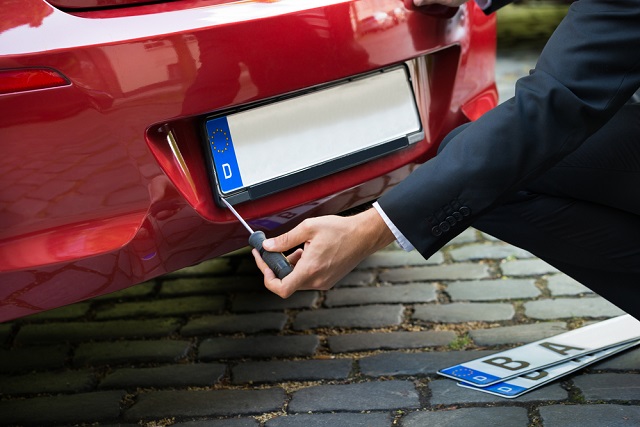 Man Changing Car's Number Plate