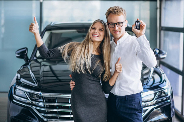 homem-e-mulher-escolhendo-um-carro-em-uma-sala-de-exposicoes_1303-17452
