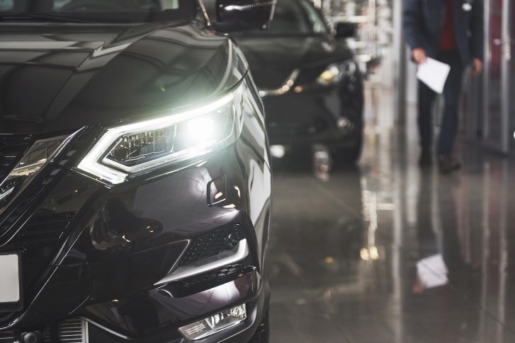 The headlights and the hood of a black luxury car